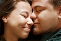 Emotional portrait of affectionate smiling kissing couple, close-up view