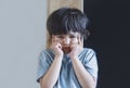 Emotional portrait Angry aggressive kid,Child standing  alone with upset or sad face, Little trouble boy covered his face with Royalty Free Stock Photo