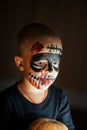 Emotional portrait of a boy with a scary zombie on his face and a pumpkin, horror concept - screaming the walking dead zombie Royalty Free Stock Photo