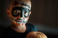 Emotional portrait of a boy with a scary zombie on his face and a pumpkin, horror concept - screaming the walking dead zombie Royalty Free Stock Photo