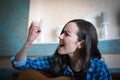 Emotional portrait of a brunette woman broke her nail playing an acoustic guitar. learning music, funny moment