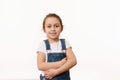 Emotional portrait of a cute baby girl, wearing blue denim overalls, isolated over white background with copy ad space Royalty Free Stock Photo