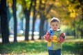 Emotional portrait of a happy and cheerful little boy laughing. yellow flying maple leaves while walking in the autumn park. Happy