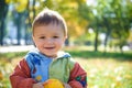 Emotional portrait of a happy and cheerful little boy laughing. yellow flying maple leaves while walking in the autumn park. Happy