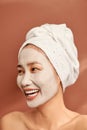Emotional portrait of a happy and positive beautiful nude young woman with a clay cosmetic mask on her face Royalty Free Stock Photo