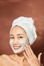 Emotional portrait of a happy and positive beautiful nude young woman with a clay cosmetic mask on her face Royalty Free Stock Photo