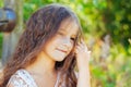 Emotional portrait of a little girl with long hair, summer day