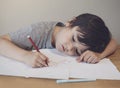 Emotional portrait of lonely child writing a messages to his mother, Preschool kid using red colour writing and drawing on white