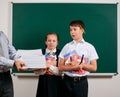 Emotional portrait of a schoolboy and schoolgirl get a lot of books, posing with notebooks, pens, pencils and other school Royalty Free Stock Photo