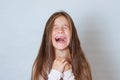 Emotional portrait of strong emotions tears of a little beautiful girl on a white background