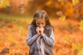 Emotional portrait of a tired and lonely little girl. Autumn mood. Walk in the autumn park. Lifestyle Royalty Free Stock Photo