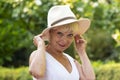 Emotional portrait of a woman 60-70 years old beautiful blonde in a straw hat on the background of nature. Royalty Free Stock Photo