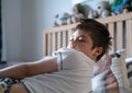 Emotional portrait young boy lying on bed, Sleepy child waking up the morning in his bed room with morning light, Kid 7 year old Royalty Free Stock Photo