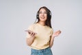 Emotional portrait of Young happy asian woman with long hair in yellow shirt and jeans using mobile phone listening music by Royalty Free Stock Photo