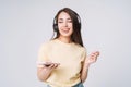 Emotional portrait of Young happy asian woman with long hair in yellow shirt and jeans using mobile phone listenong music by Royalty Free Stock Photo