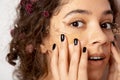 Emotional positive woman with flowers at her curly hair