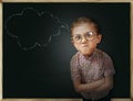 Emotional pupil boy near chalkboard