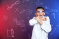 Emotional pupil shielding himself against blackboard with written chemistry formulas