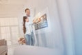 Emotional relatives smiling while standing near the wall and touching a gadget Royalty Free Stock Photo