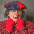 Emotional sad expression face, female clown in red end blue colors Royalty Free Stock Photo