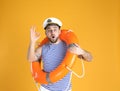 Emotional sailor with ring buoy on yellow background