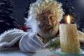 Emotional Santa Claus congratulating with New Year and Christmas, writing a letter, wish list in midnight with candle Royalty Free Stock Photo