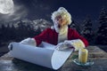 Emotional Santa Claus congratulating with New Year and Christmas, writing a letter, wish list in midnight with candle Royalty Free Stock Photo