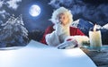 Emotional Santa Claus congratulating with New Year and Christmas, writing a letter, wish list in midnight with candle Royalty Free Stock Photo