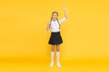 Emotional schoolgirl. Celebrate knowledge day. September time to study. Girl adorable pupil on yellow background. School