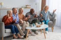 Emotional senior people watching television in the living room Royalty Free Stock Photo