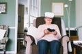 Emotional senior woman wearing virtual reality goggles and using wireless controller, joystick gamepad playing video Royalty Free Stock Photo