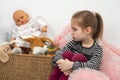 Emotional shot of a little girl sitting with her toys and sad about something Royalty Free Stock Photo