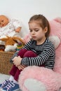 Emotional shot of a little girl sitting with her toys and sad about something Royalty Free Stock Photo