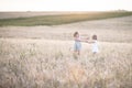 Emotional sisters on wheat field at sunset