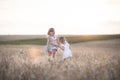 Emotional sisters on wheat field at sunset