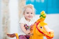 Emotional smiling little girl riding on the carousel