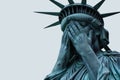 Emotional statue of liberty with her head in hands. American state of grief and depression