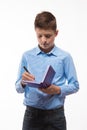 Emotional teenager boy brunette in a blue shirt with a diary and a pen in hand