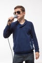 Emotional teenager boy brunette in sunglasses with a microphone