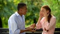 Emotional teenagers arguing and quarreling sitting on bench in park, conflict