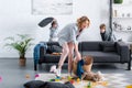 emotional tired mother putting toys in basket while naughty kids