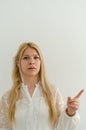 Blond girl is frowning eyebrows and lifting her index finger pointing Royalty Free Stock Photo