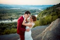 Emotional wedding shot of newlyweds. Happy couple is smiling and hugging at the background of the beautiful landscape Royalty Free Stock Photo