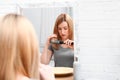 Emotional Woman Brushing Hair Near Mirror