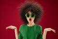 emotional woman gesturing with her hands afro hairstyle green glasses