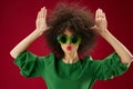 emotional woman gesturing with her hands afro hairstyle green glasses