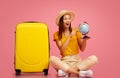 Emotional woman with globe sitting next to luggage Royalty Free Stock Photo