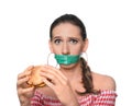 Emotional woman with measuring tape around her mouth and tasty burger on white background. Diet concept
