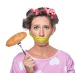 Emotional woman with measuring tape around her mouth and tasty croissant on white background. Diet concept