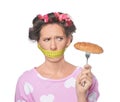 Emotional woman with measuring tape around her mouth and tasty croissant on white background. Diet concept